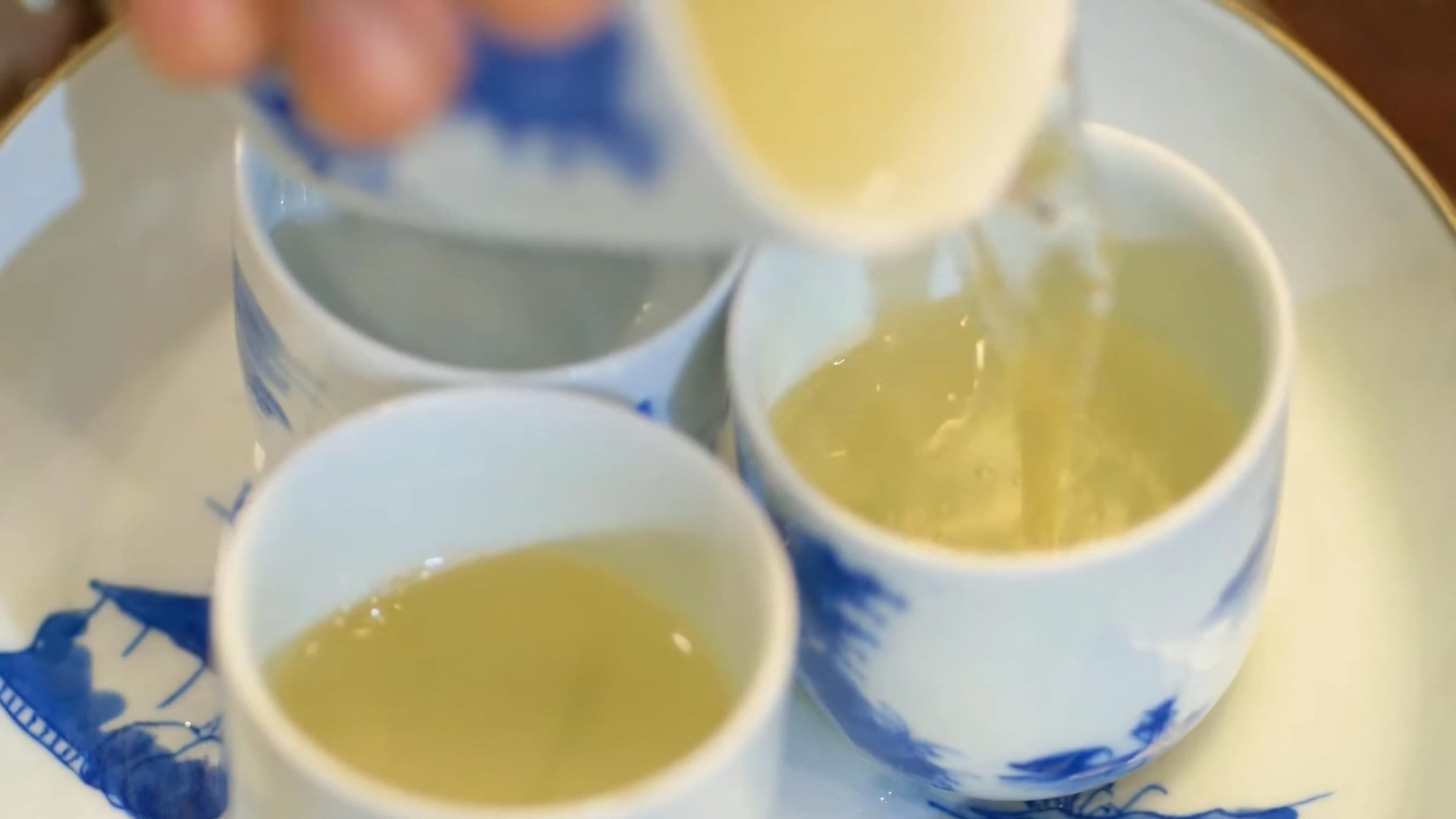 pour-tea-from-the-pitcher-into-individual-cups